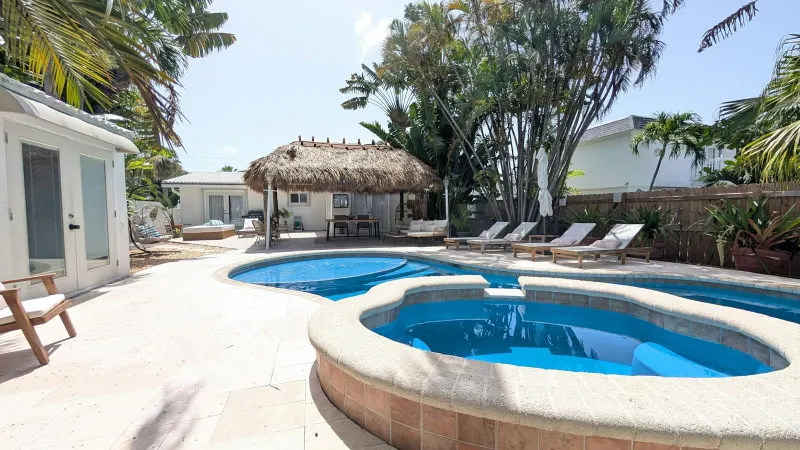 Hot tub beside the pool and tiki hut
